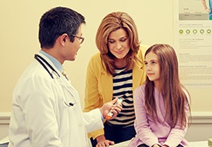 Doctor, young girl, and adult woman in exam room