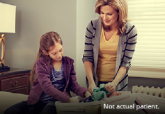 Adult and child packing suitcase together