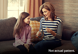 Adult demonstrating trainer device to child