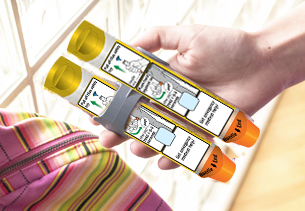 Auto injectors being held in a hand